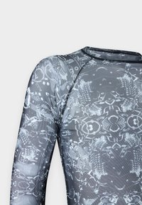 Long-sleeve, fitted top in a dark gray hue with geometric patterns. Made from a smooth, stretchy fabric with a rounded neckline.