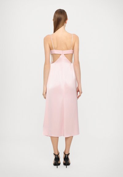Vestido de satén rosa claro con un corte a media longitud, tirantes finos y recortes en la espalda. Cuenta con un cierre de botón en la parte posterior. Textura suave.