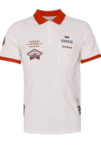 Biała koszulka polo z czerwonym kołnierzykiem i brzegami rękawów, haftowany tekst i motywy gwiazdy na klatce piersiowej oraz naszywkach rękawów, zamek błyskawiczny przy kołnierzyku, kieszeń z przodu.