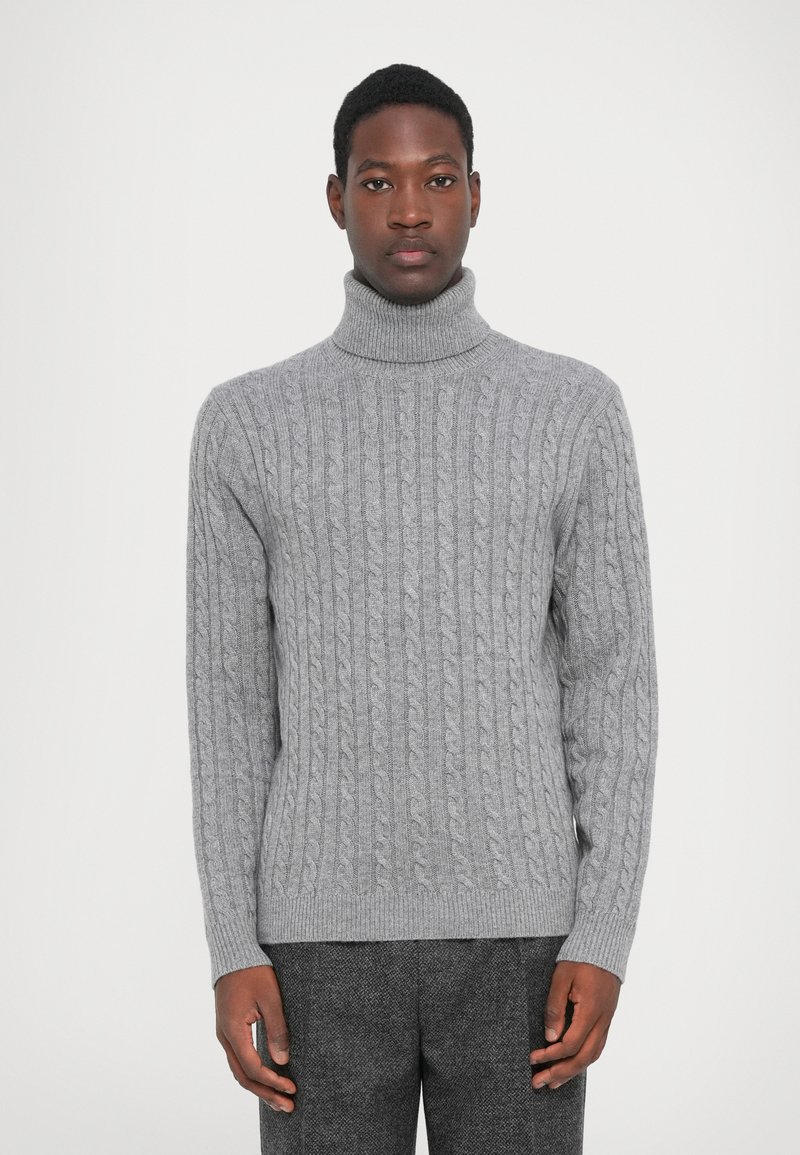 Lys grå kabelstrikket sweater med høj turtleneck, prydet med teksturerede mønstre samt ribbede manchetter og kant. Blødt, varmt materiale.