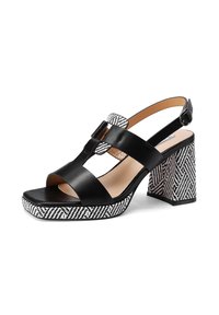 Sandalo slingback in pelle nera con cinturini larghi, punta quadrata e tacco a blocco con motivo a righe bianche e nere che presenta un design a spina di pesce.