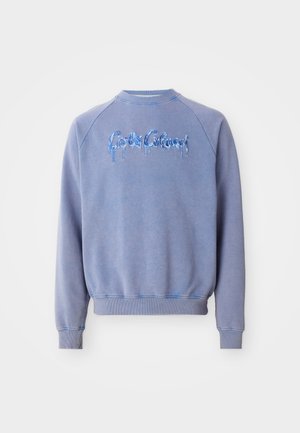 Sudadera azul claro con cuello redondo y mangas raglán. Presenta texto bordado goteante en azul en la parte delantera y puños acanalados.