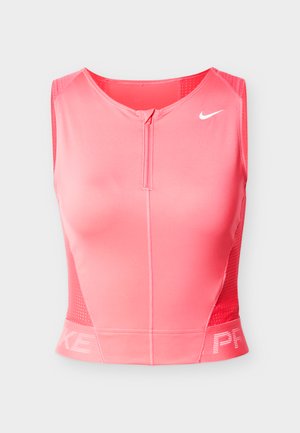 Top sportivo corto Nike rosa con scollo rotondo, cerniera frontale e dettagli in mesh sui lati. Presenta il logo Nike e la scritta "PRKE" all'orlo.