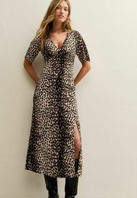 Vestido de estampado de leopardo con mangas cortas, escote en V profundo y abertura alta hasta el muslo, hecho de una tela suave con una silueta fluida.