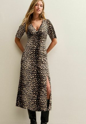 Robe à imprimé léopard avec des manches courtes, décolleté en V profond et fente jusqu'à la cuisse, fabriquée dans un tissu doux avec une silhouette fluide.
