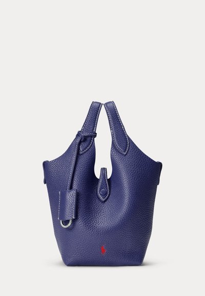 Dark blue textured leather handbag with two handles, a small flap with button closure, and a red logo near the bottom center.
