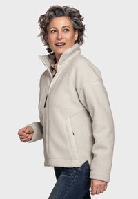 Fleecejacke in Hellgrau mit hohem Kragen, Frontreißverschluss und Seitentaschen. Weiche Textur, lässige Passform und Kontrastdetails am Saum.