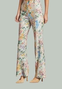 Floral geprinte flare-broeken in pastelkleuren, gemaakt van een lichte stof met een zachte textuur en een getailleerde pasvorm rond de taille en benen.