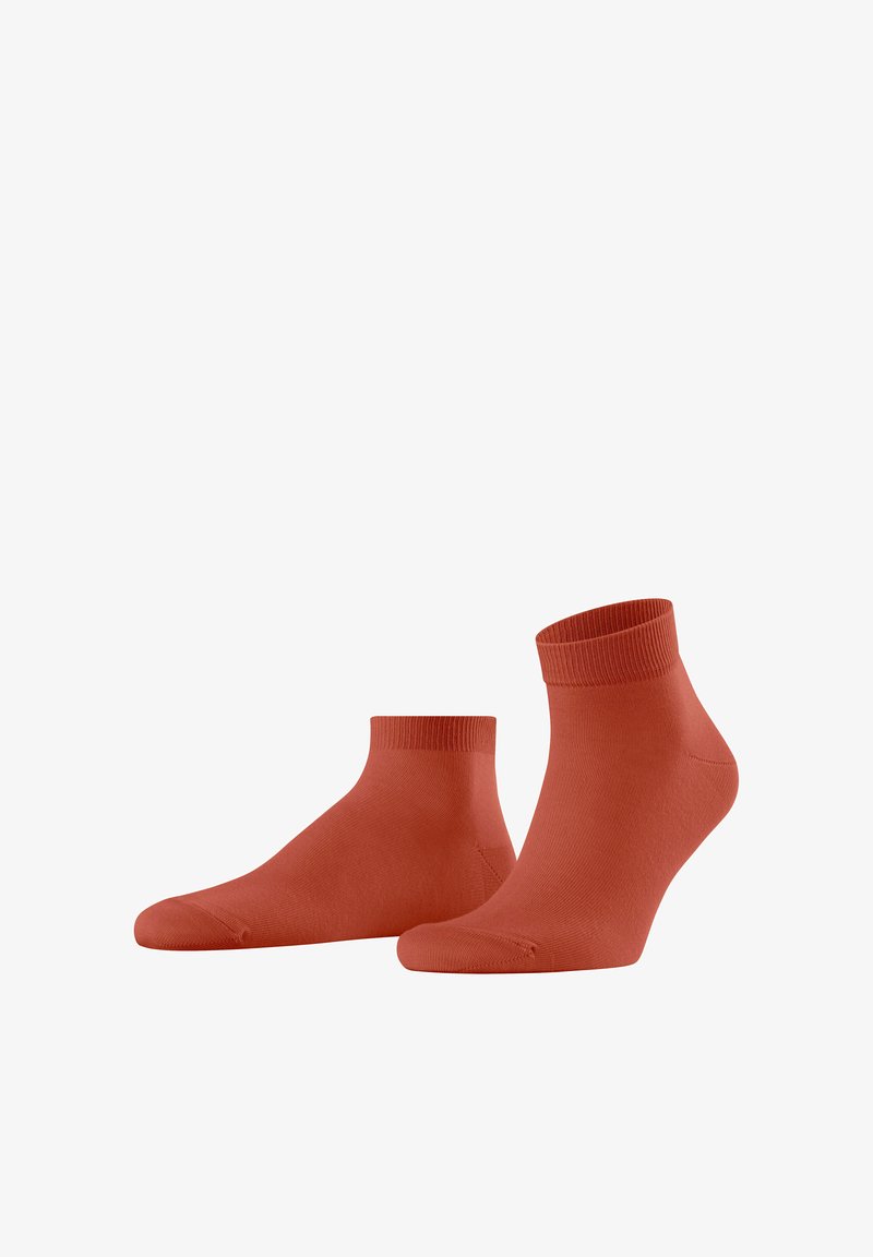 Chaussettes de cheville rouges avec des bords côtelés, texture lisse et design sans couture au niveau des orteils. Fabriquées en matériau doux et extensible pour un confort optimal.