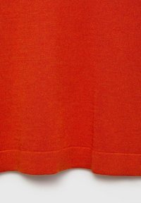 Orangener Strickstoff mit glatter Textur, der einen gerippten Saum und subtile Texturdetails über die Oberfläche aufweist.