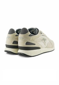Sneaker rétro in suede beige, con accenti in mesh grigio, suola bianca imbottita e dettagli di marca sul tallone.