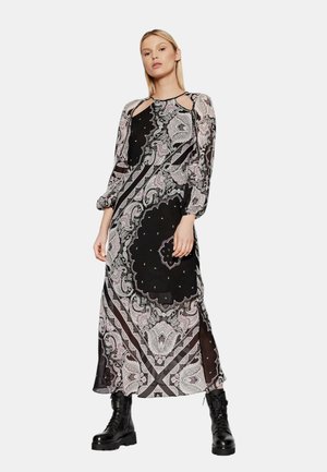 Abito maxi nero con motivi paisley ornamentali in bianco e rosa, caratterizzato da maniche lunghe, aperture sulle spalle e una silhouette fluida.