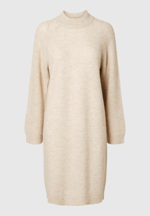 Bež pletenudress, millel on kõrge kaelus, pikad varrukad ja lahti ülikond koos soonikservadega. Pehme tekstuur ja keskmise pikkusega kujundus.