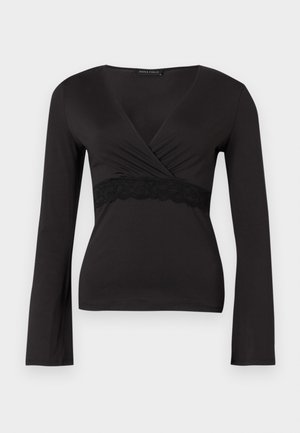 Juoda ilgomis rankovėmis apykaklės viršutinė dalis su V formos iškirpte ir nėriniu po krūtinėle, prigludusi siluetas.