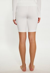 Shorts da ciclismo bianchi elasticizzati con una texture liscia, design alla lunghezza del ginocchio e rifiniture a contrasto. Vestono aderenti in vita e cosce.