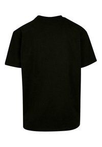 Camiseta de algodón negra con manga corta y cuello redondo, con un color sólido y un corte holgado. Sin patrones ni acentos visibles.