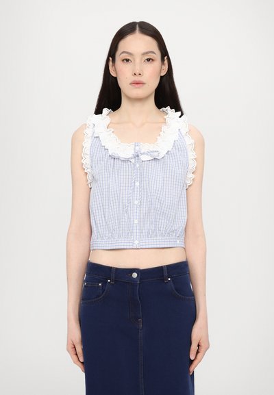 Blue and white checkered cropped top with a ruffled white neckline, button closure, and elasticized waistband, paired with a dark denim skirt.