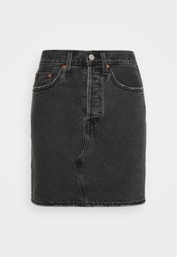 Svart denimkjol med åtsittande midja, femfickorsdesign och kontrasterande orange sömmar. Har en framdragkedja och metallknappstängning.