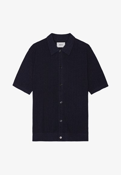 Maglietta a maniche corte in maglia a coste blu navy con colletto abbottonato e bottoni frontali. Presenta un orlo dritto e un dettaglio in tessuto testurizzato.