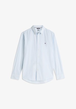 Svetlomodra in bela s pokončnimi navpičnimi črtami, dolga srajca z gumbi, ovratnikom in majhno vezeno oznako na prsih.