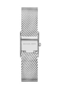 Banda de reloj de metal con malla plateada y cierre abatible grabado "Michael Kors," fotografiada en posición plana sobre un fondo blanco.