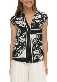 Schwarze kurzärmlige Bluse mit tiefem Ausschnitt, die ein großes weißes Blumenmuster aufweist und einen lockeren Schnitt hat, aus glattem Stoff gefertigt.