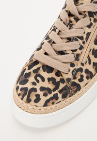 Leopardmønstrede sneakers i beige ruskind, med beige snørebånd, en vævet jute mellemsål og en hvid gummisål.