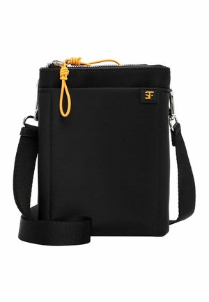Czarna torebka na ramię z regulowanym paskiem, zamkiem błyskawicznym u góry z pomarańczowym sznurkiem do ciągnięcia oraz małą metką z logo na przedniej kieszeni.