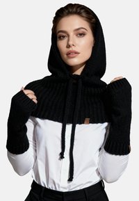 Felpa nera lavorata a maglia con maniche lunghe e fori per il pollice, caratterizzata da una texture a coste, coulisse e un piccolo tag con marchio sul lato.