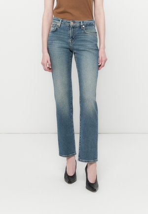 Light blue straight-leg jeans made of denim, featuring a mid-rise waist, subtle fading, and classic five-pocket design. Paired with black heels.