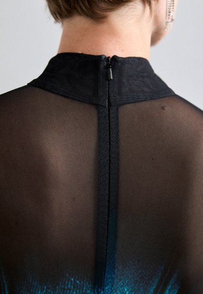 Top nero trasparente con collo alto, dotato di una cerniera sul retro e di un motivo blu sfumato all'orlo, che mette in risalto la texture trasparente.