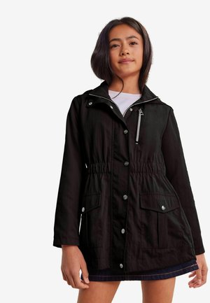 Giacca leggera nera con vita regolabile tramite cordoncino, hardware argento, bottoni a pressione e due tasche frontali, caratterizzata da un colletto e dettagli con zip.