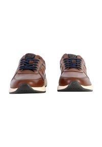 Sneaker in pelle marrone con lacci blu navy, suola crema, punta rotonda e suola in gomma nera testurizzata. Dettagli di cucitura leggeri sui lati.