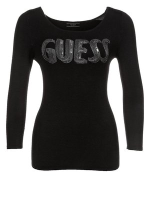 Schwarzer, langärmeliger, figurbetonter Pullover mit dem glitzernden "GUESS"-Logo auf der Brust und einem breiten, runden Ausschnitt.