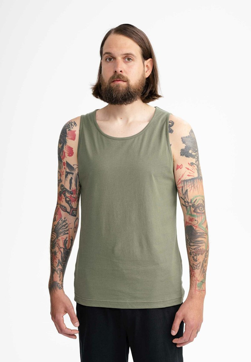 Groene katoenen mouwloze tanktop met een ronde hals. Kenmerkt zichtbare tatoeages op de armen, minimalistisch ontwerp en een relaxte pasvorm.