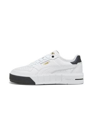 Witte Puma-sneaker met zwarte zool aan de voorkant, gouden Puma-logo aan de zijkant, gevoerde kraag en gestikte details, weergegeven in een linkerprofiel.