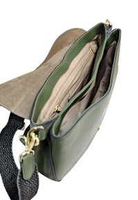Borsa in pelle verde con interni beige, dotata di più scomparti e una tracolla nera texture con dettagli in oro.