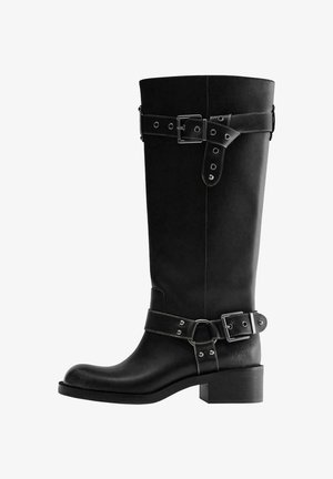 Black knee-high leather boot with low block heel, round toe, and decorative straps with silver buckles around ankle and top shaft.
