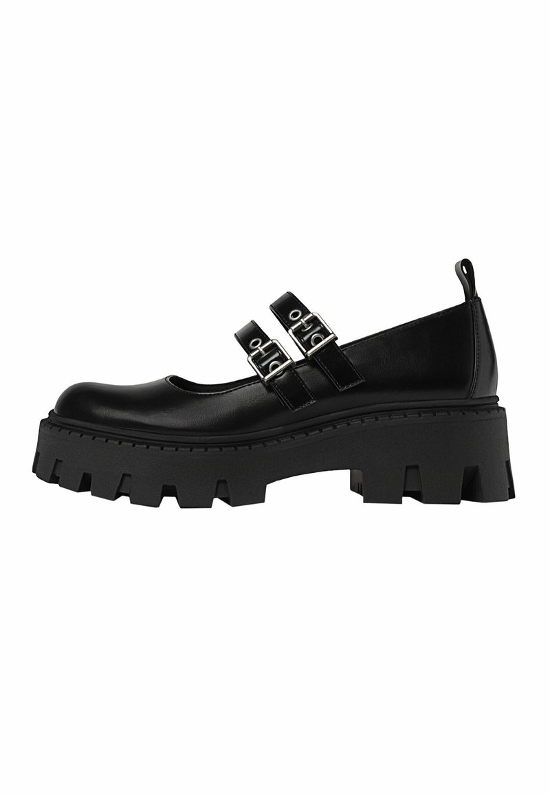 Chaussure plateforme noire épaisse avec deux brides réglables à boucle argentée et une languette au talon.