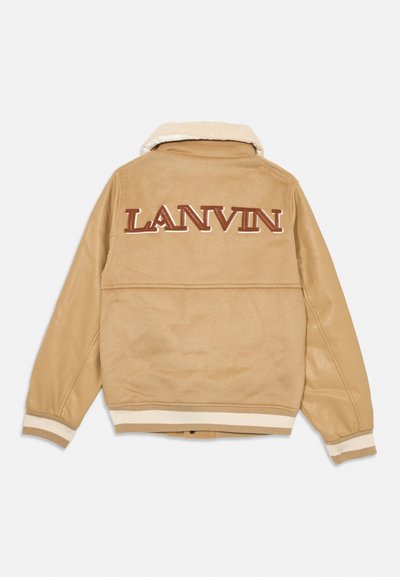Bež bomber jakna s teksturiranim, umjetnim krznom ovratnikom. Ima veliki "LANVIN" logo u smeđoj boji na leđima i prugaste rebraste manžete.