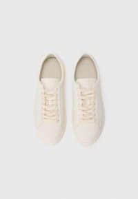 Pair of off-white leather sneakers with laces, viewed from above, on a plain white background.