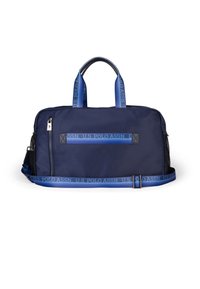 Námořnická duffle taška vyrobená z odolné tkaniny, s dvojitými rukojeťmi, nastavitelným popruhem a páskou s logem podél horní části.