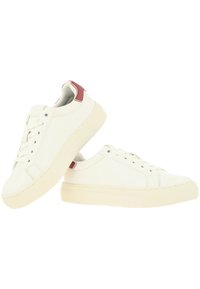 Witte canvas sneakers met een textuurafwerking, rubberen zool en rode accenten op de hiel. Voorzien van een vetersluiting met zes oogjes.