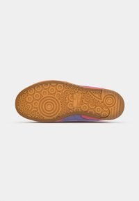Shoe sole featuring a gum brown rubber base with circular and patterned grip details; accented with purple and pink sections.