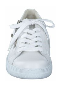 Zapatilla blanca con parte superior de cuero liso, puntera redonda, cordones planos, cremallera lateral y suela de goma texturizada. Diseño limpio y minimalista.