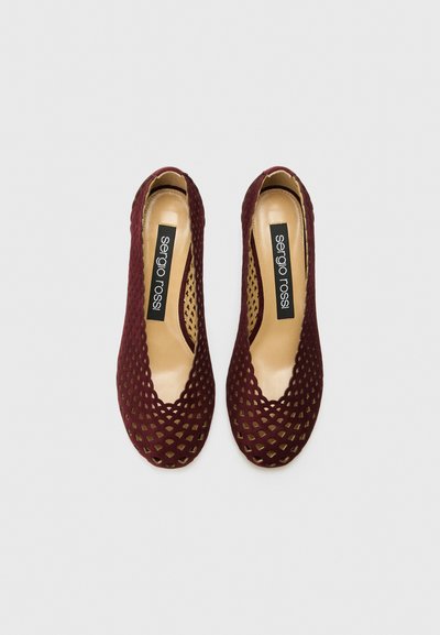 Ballerine in suede borgogna con un design perforato, punta arrotondata e interno beige liscio con il logo "Sergio Rossi".