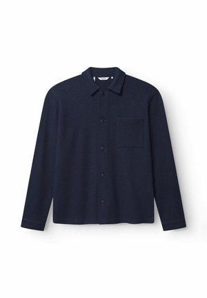 Sötétkék gombos ing gyapjú keverékből, pont gallérral, hosszú ujjakkal és egy mellzsebbel, amely texturált anyagból készült.