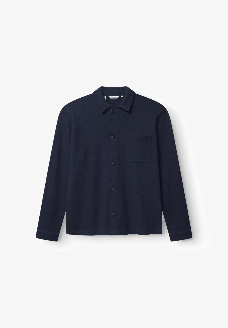 Chemise boutonnée bleu marine en mélange de laine, présentant un col pointu, des manches longues et une poche poitrine avec une finition en tissu texturé.