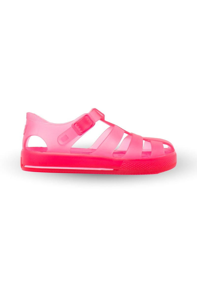 Pink transparent sandals with a rubber texture, featuring multiple side cutouts, two central straps, and an adjustable buckle closure.