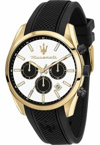 Gouden horloge met een witte wijzerplaat, drie zwarte subdials en een datvenster. Voorzien van een zwarte rubberen band met een gepatineerde textuur en drukknoppen.